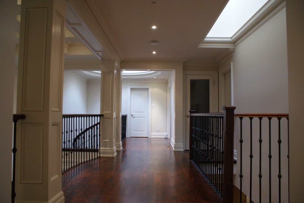 Aménagement d'un couloir classique de taille moyenne avec un mur blanc, parquet foncé et un sol marron.