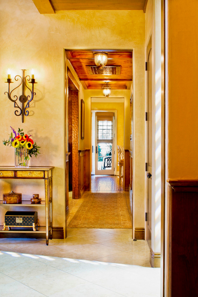 Tuscan white floor and limestone floor hallway photo in Los Angeles with white walls