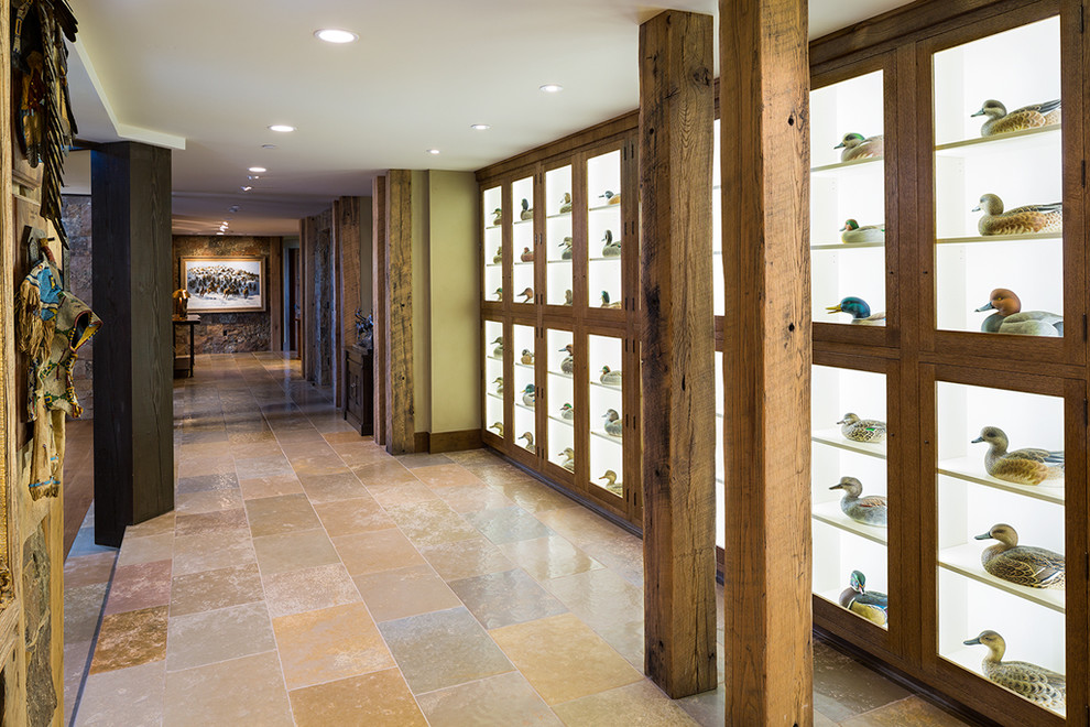 他の地域にあるラグジュアリーな広いラスティックスタイルのおしゃれな廊下 (ライムストーンの床、ベージュの壁、マルチカラーの床) の写真