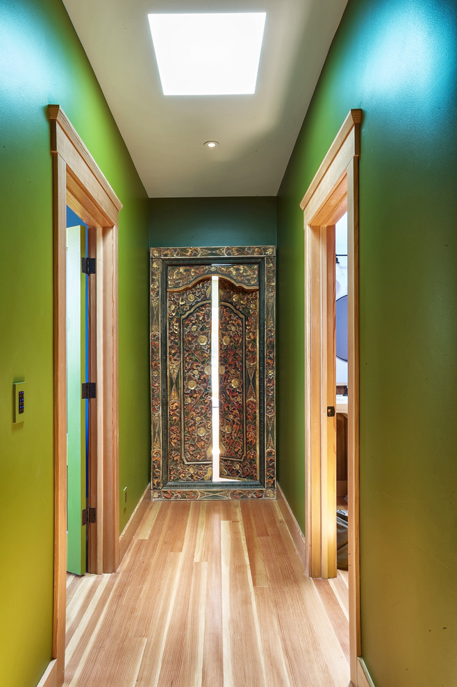 Esempio di un ingresso o corridoio country con pareti verdi e parquet chiaro