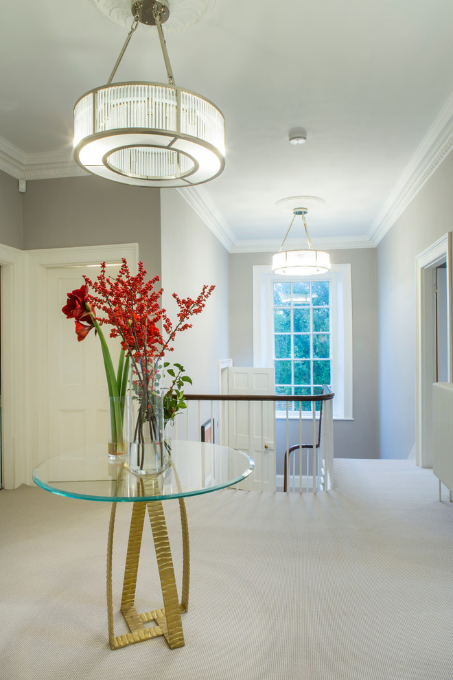 Стильный дизайн: коридор в классическом стиле с серыми стенами, ковровым покрытием и белым полом - последний тренд