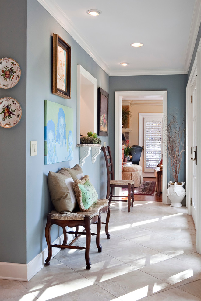 Cette image montre un petit couloir traditionnel avec un mur bleu et un sol en travertin.