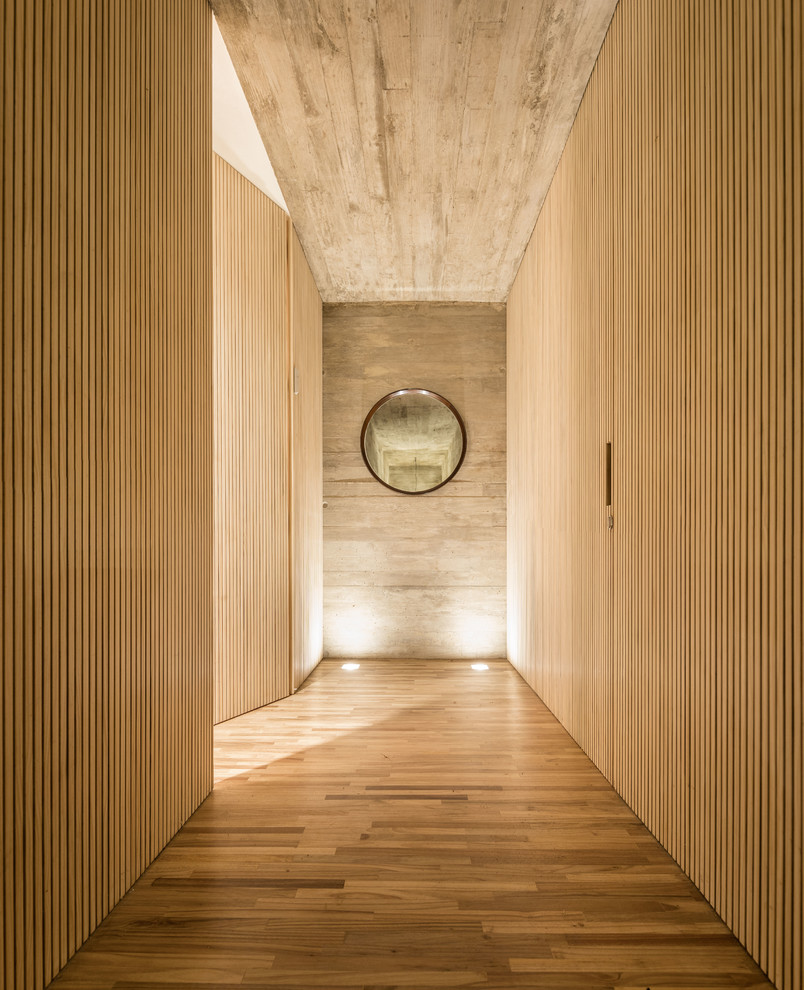Ispirazione per un ampio ingresso o corridoio minimalista con pareti beige e pavimento in legno massello medio