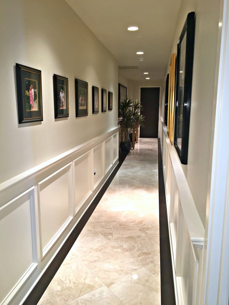 Идея дизайна: огромный коридор в стиле неоклассика (современная классика) с фиолетовыми стенами, полом из травертина и бежевым полом