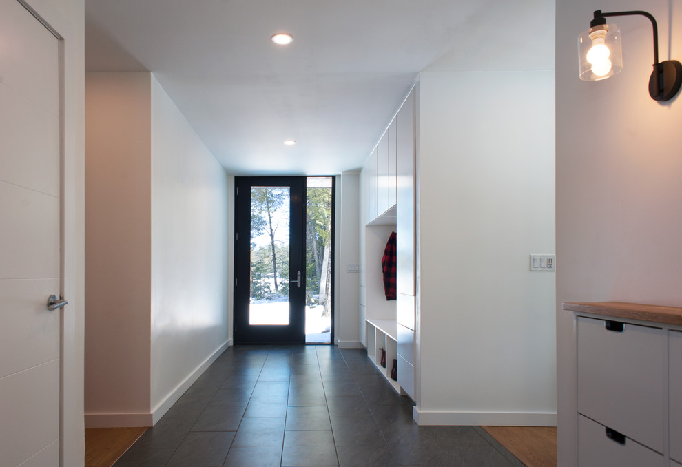 Пример оригинального дизайна: маленький коридор в современном стиле с белыми стенами, полом из керамической плитки и черным полом для на участке и в саду