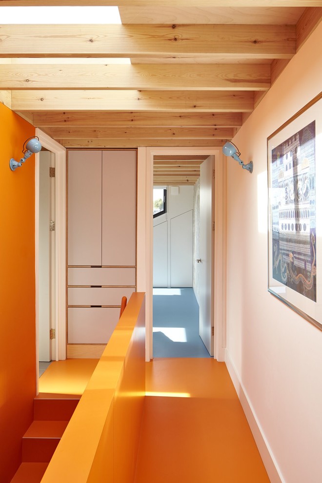Cette photo montre un couloir tendance de taille moyenne avec un mur multicolore et un sol orange.