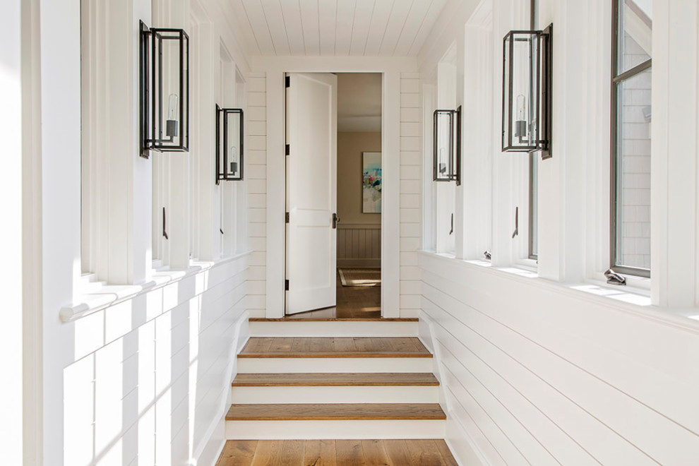 Maritimer Flur mit weißer Wandfarbe, braunem Holzboden, Holzdielendecke und Holzdielenwänden in Charleston