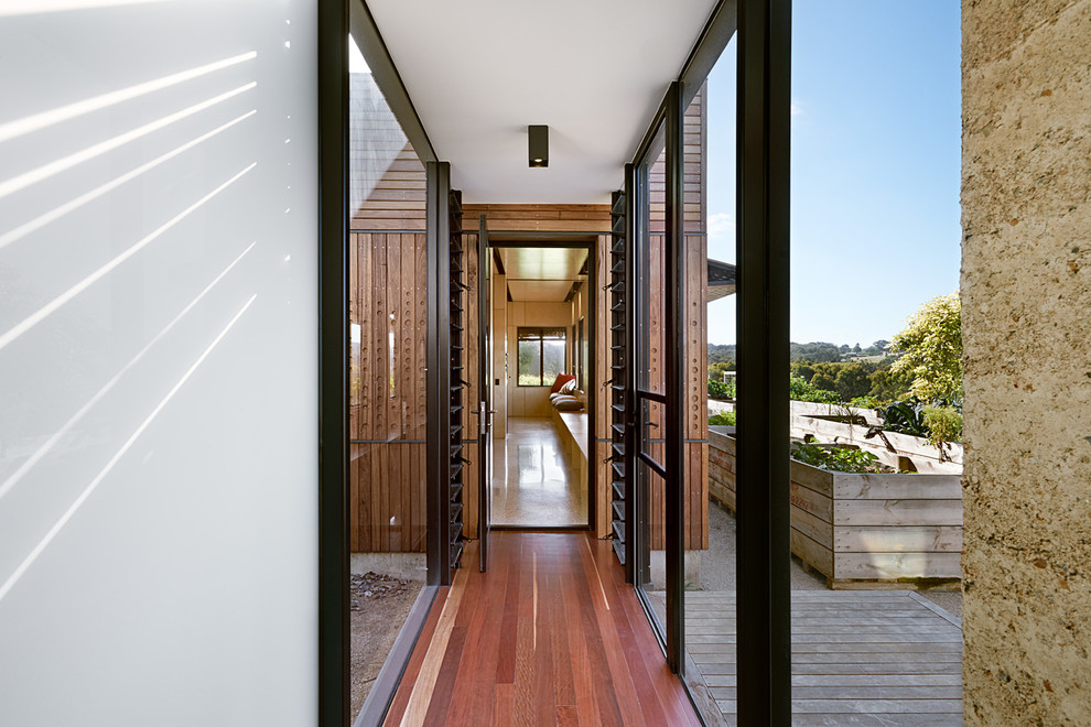 Kleiner Moderner Flur mit weißer Wandfarbe und braunem Holzboden in Melbourne