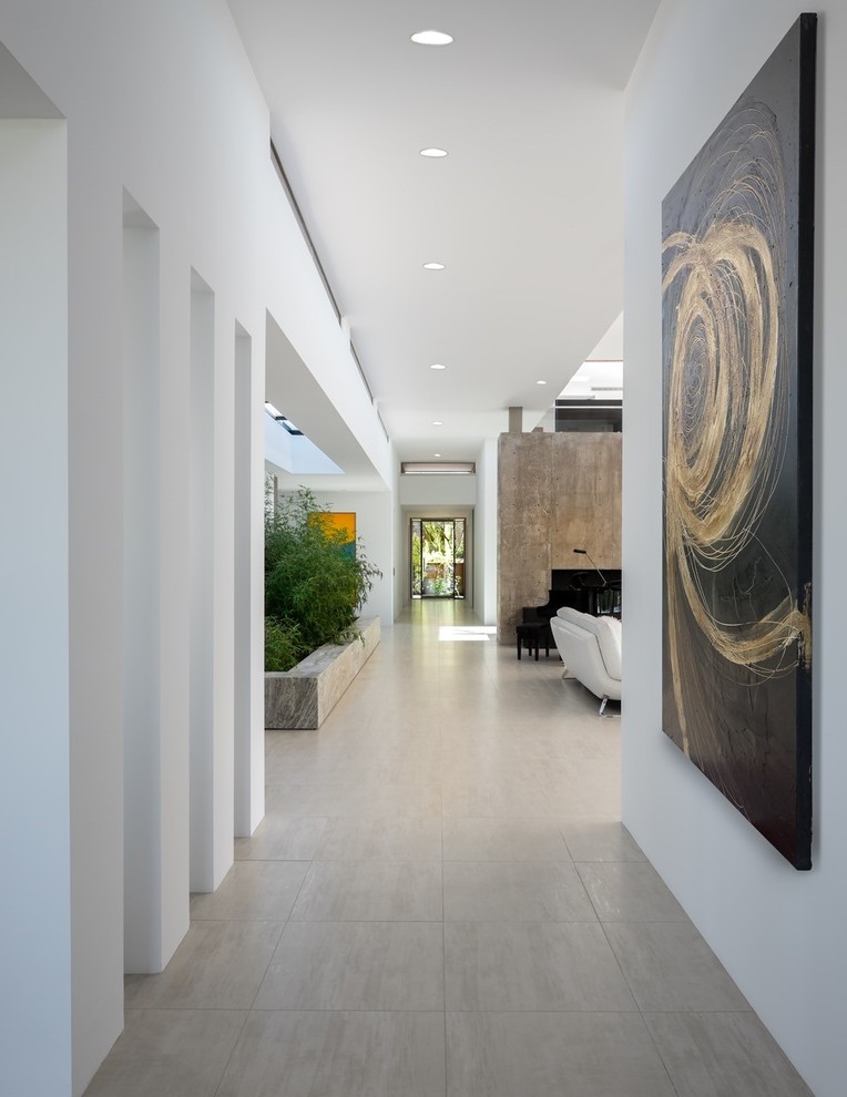 На фото: большой коридор в стиле фьюжн с полом из керамогранита, белыми стенами и серым полом с