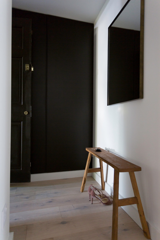 Aménagement d'un petit couloir moderne avec un mur gris et parquet clair.