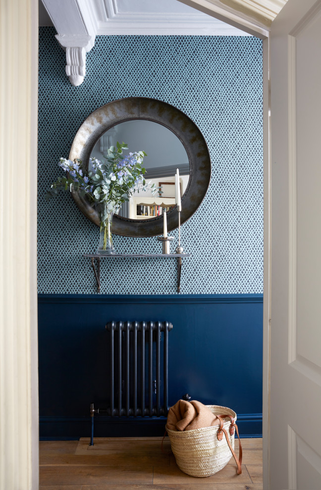 Esempio di un piccolo ingresso o corridoio classico con pareti blu, pavimento in legno massello medio e pavimento marrone