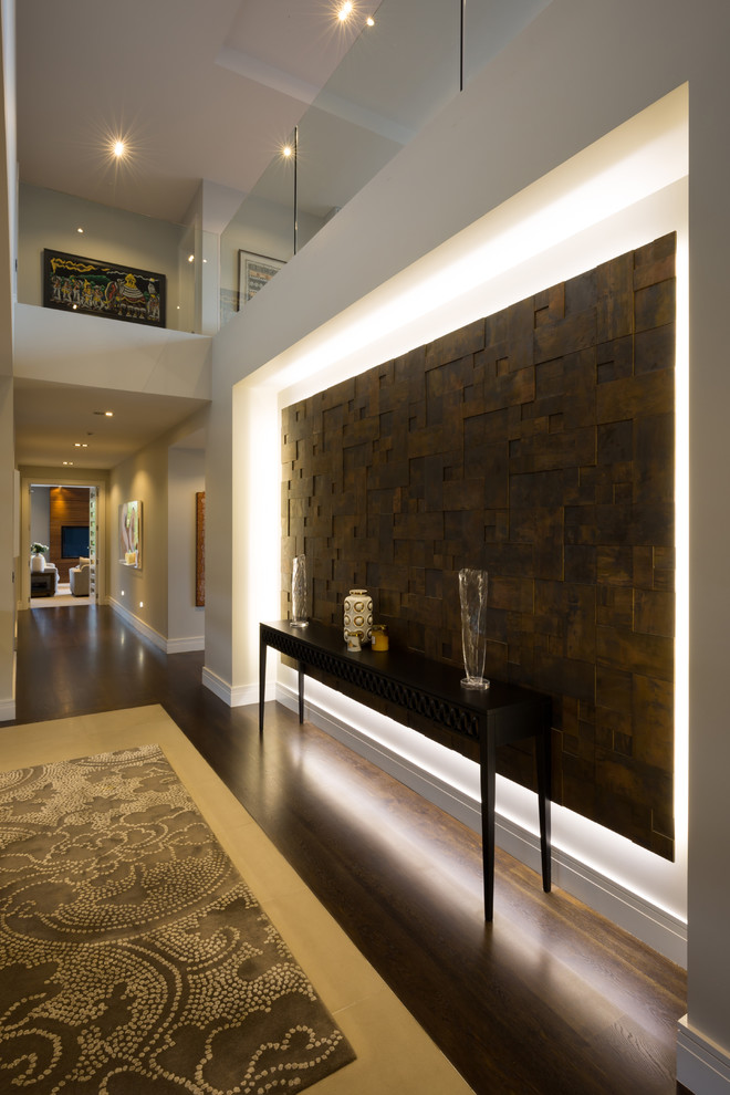 Inspiration pour un grand couloir design avec un mur beige, parquet foncé et un sol marron.