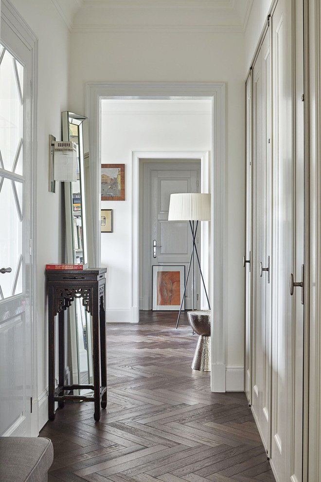 Inspiration pour un couloir traditionnel avec un mur blanc et parquet foncé.