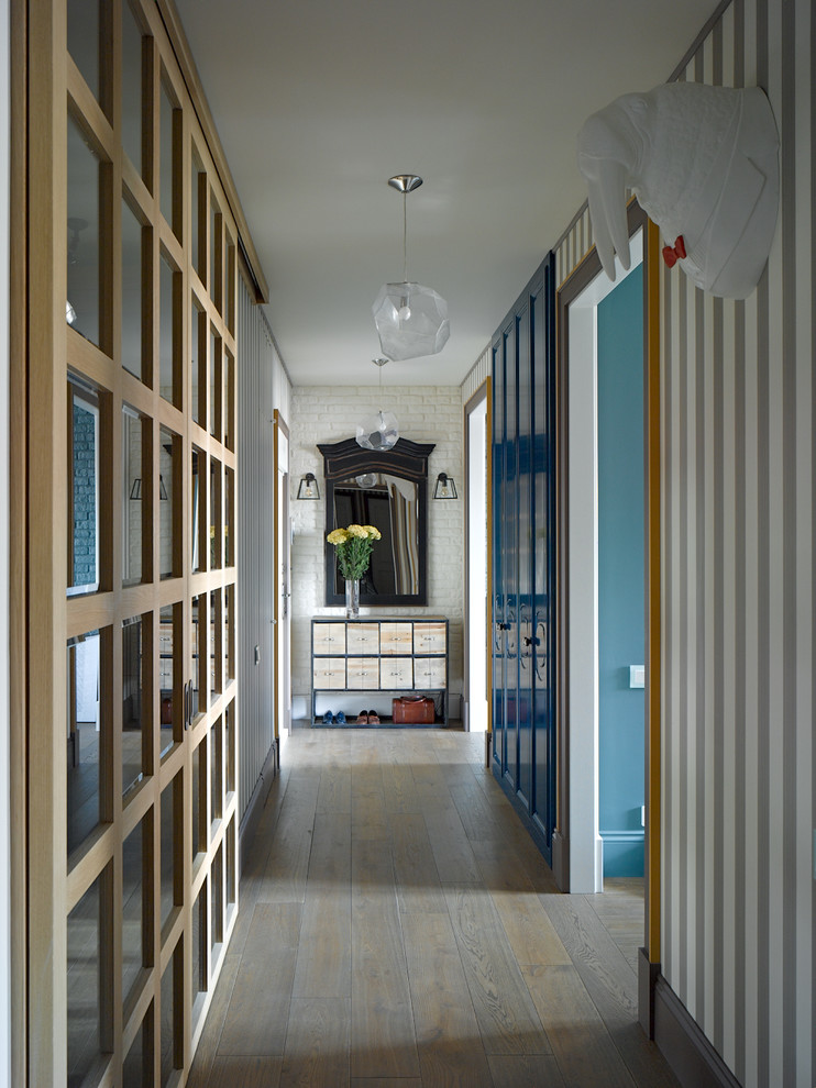 Immagine di un ingresso o corridoio bohémian con pavimento in legno massello medio