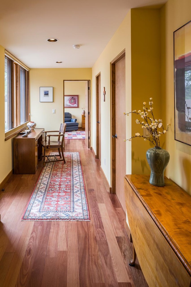 Idee per un ingresso o corridoio stile americano di medie dimensioni con pareti gialle, pavimento in legno massello medio e pavimento marrone