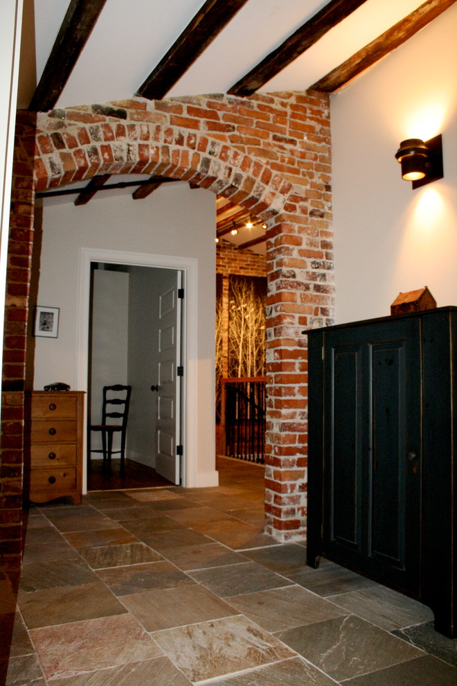 Exemple d'un couloir chic de taille moyenne avec un mur blanc et un sol en ardoise.