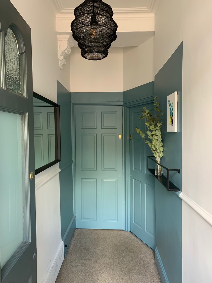 Idée de décoration pour un petit couloir bohème avec un mur bleu, moquette et un sol beige.