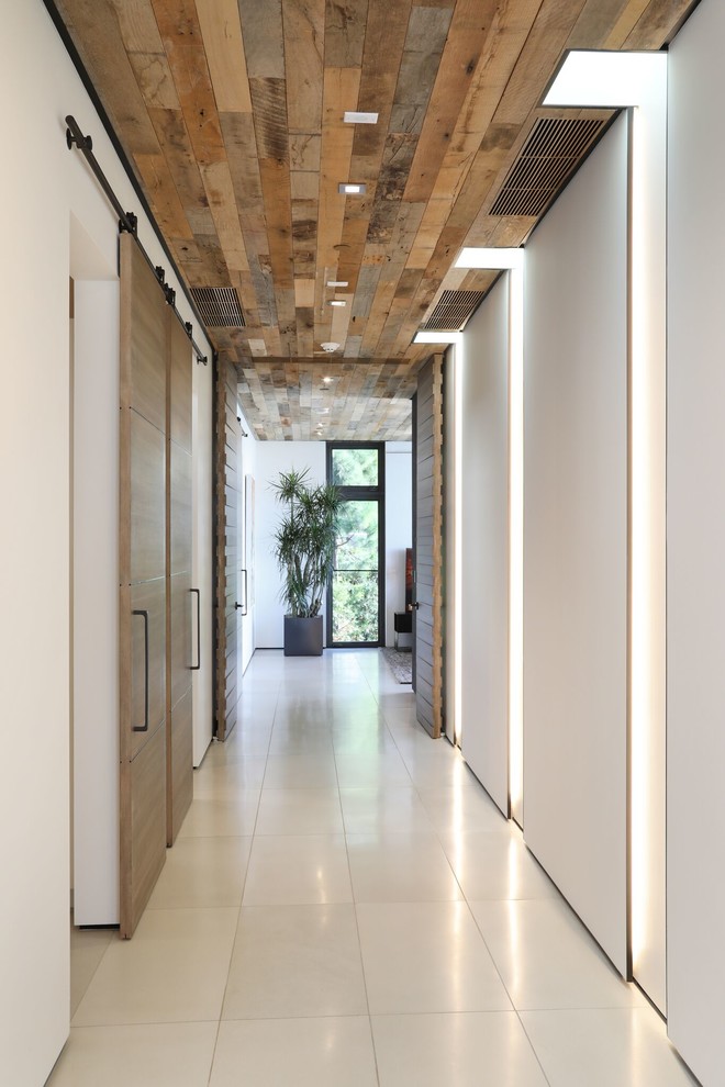 Идея дизайна: большой коридор в современном стиле с белыми стенами, полом из керамической плитки и белым полом