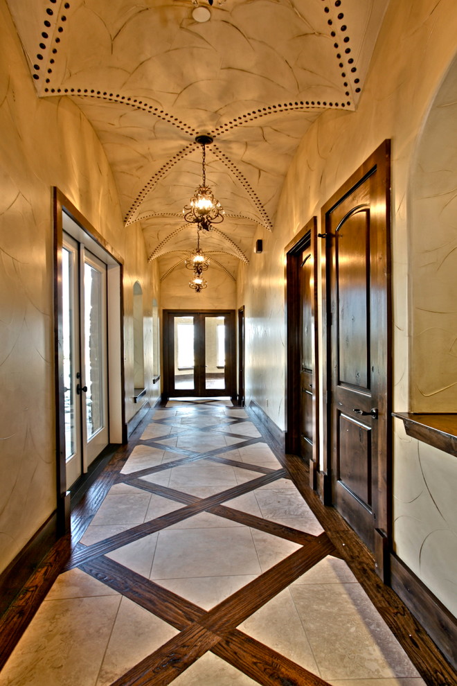 Large tuscan hallway photo in Dallas with beige walls
