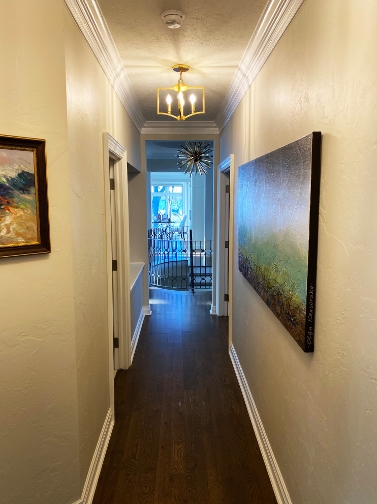На фото: огромный коридор в стиле неоклассика (современная классика) с темным паркетным полом, коричневым полом и деревянным потолком с