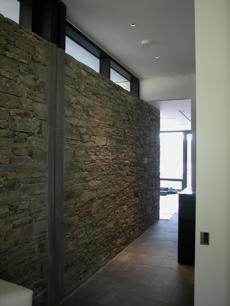Inspiration for a mid-sized modern slate floor and gray floor hallway remodel in New York with brown walls