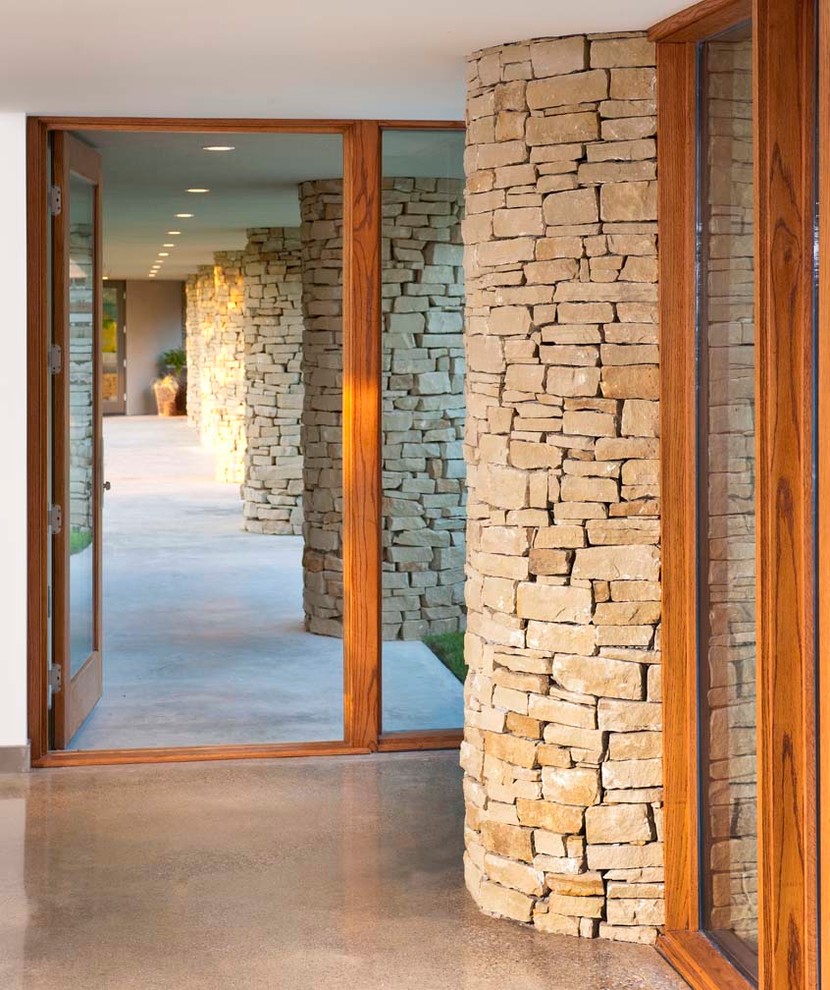 Idee per un grande ingresso o corridoio minimalista con pareti beige e pavimento in cemento