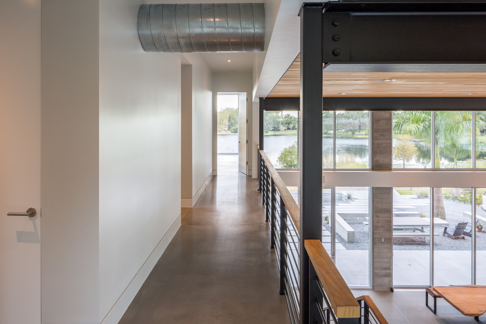 Idee per un ingresso o corridoio minimalista di medie dimensioni con pareti bianche e pavimento in cemento