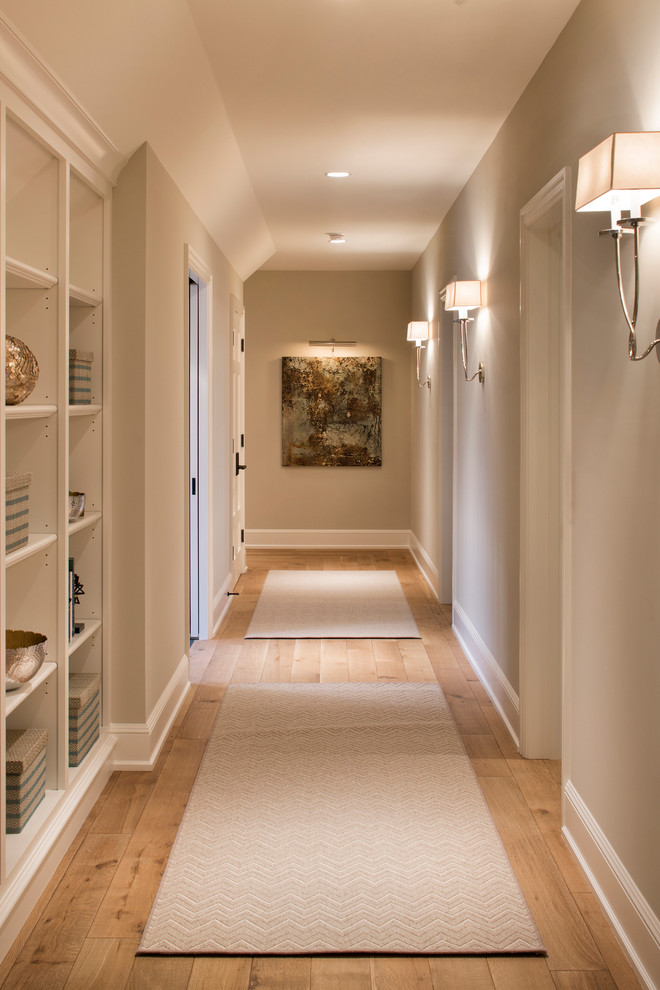 Inspiration pour un grand couloir avec un mur beige et un sol en bois brun.