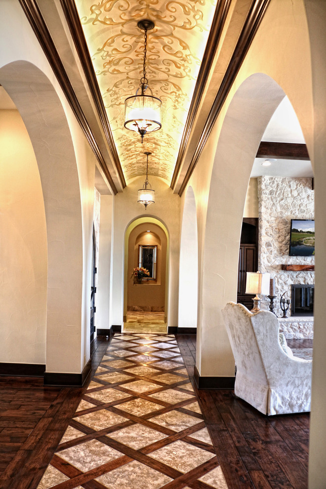 Hallway - large mediterranean dark wood floor hallway idea in Austin with white walls