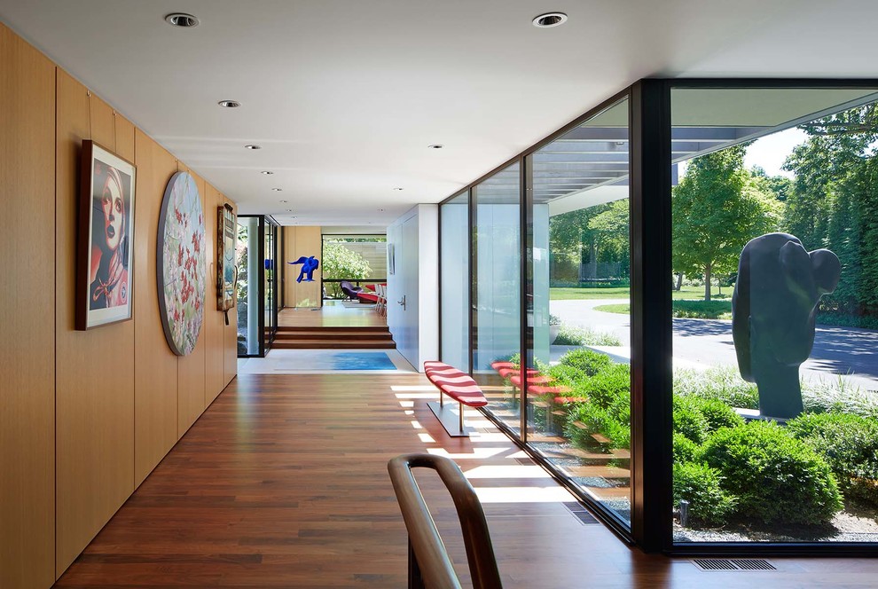 Idée de décoration pour un grand couloir design avec un sol en bois brun.