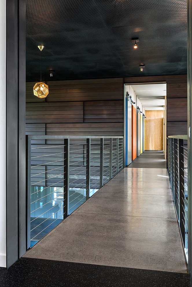 Immagine di un ingresso o corridoio design con pareti marroni, pavimento in cemento e pavimento grigio