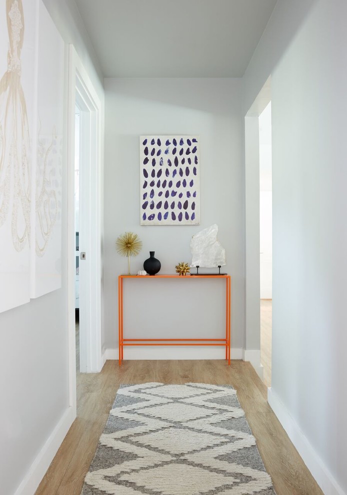 Mid-sized transitional medium tone wood floor hallway photo in Dallas with gray walls