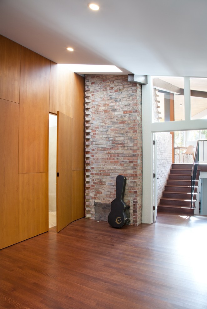 Immagine di un ingresso o corridoio moderno di medie dimensioni con pareti marroni, pavimento in legno massello medio e pavimento marrone