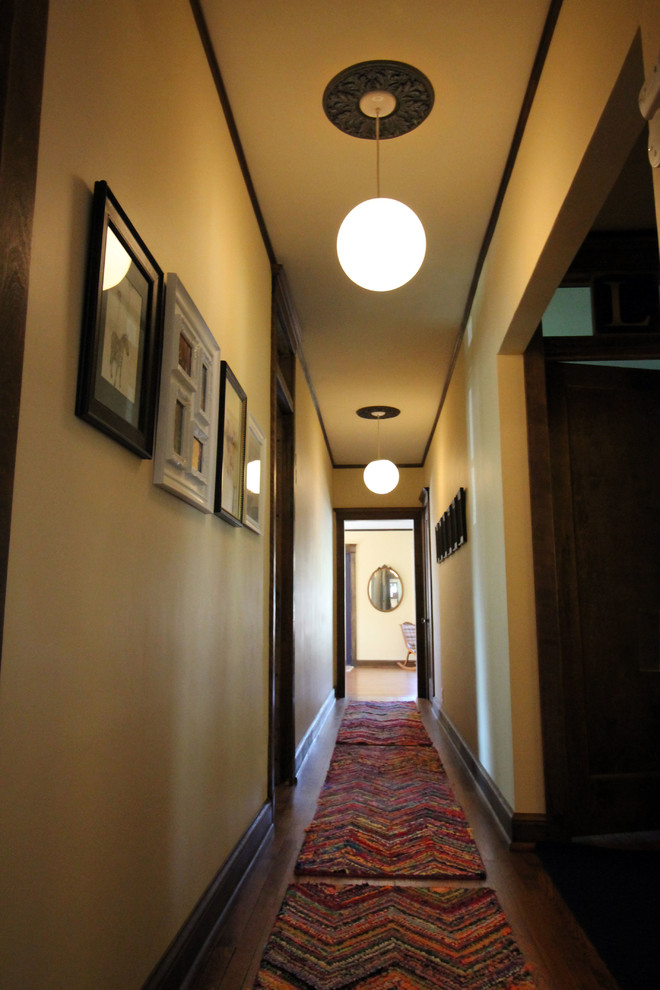 Exemple d'un couloir éclectique de taille moyenne avec un mur beige et un sol en bois brun.