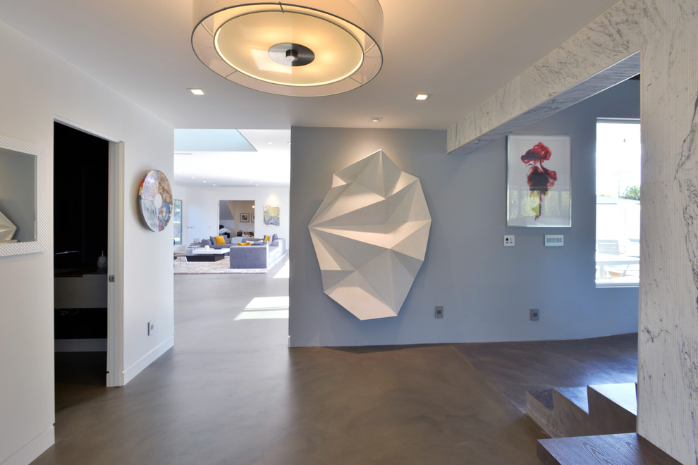 Hallway - mid-sized modern concrete floor hallway idea in Los Angeles with white walls
