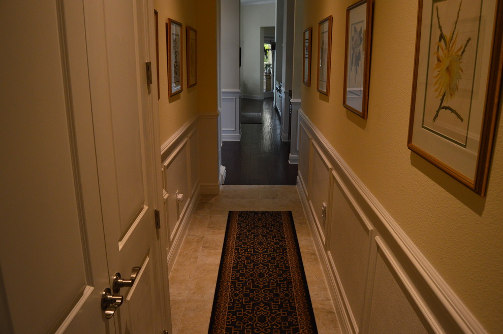 На фото: коридор среднего размера в классическом стиле с желтыми стенами и полом из травертина