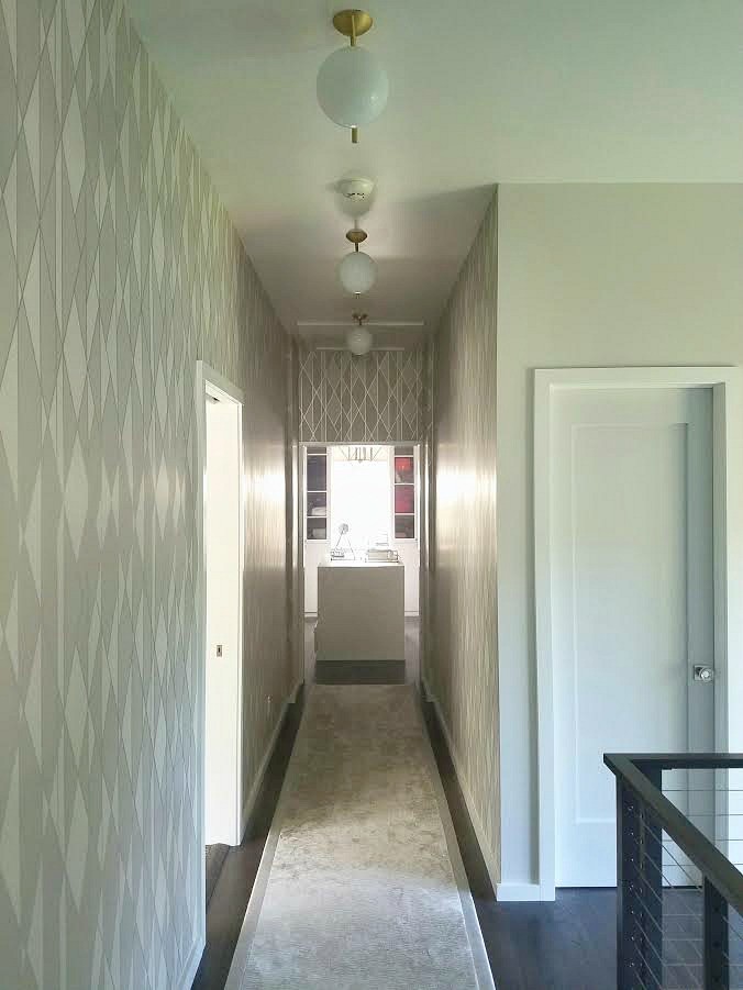 Ejemplo de recibidores y pasillos minimalistas de tamaño medio con paredes grises, suelo de madera en tonos medios y suelo marrón