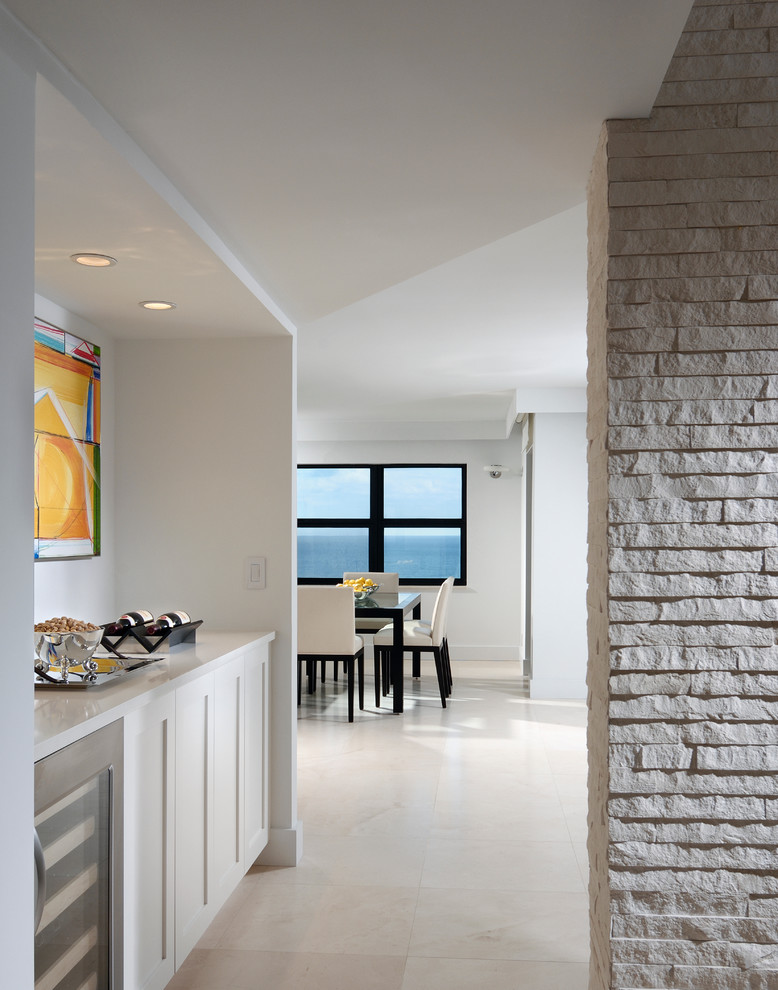 Hallway - mid-sized contemporary porcelain tile and beige floor hallway idea in Miami with white walls