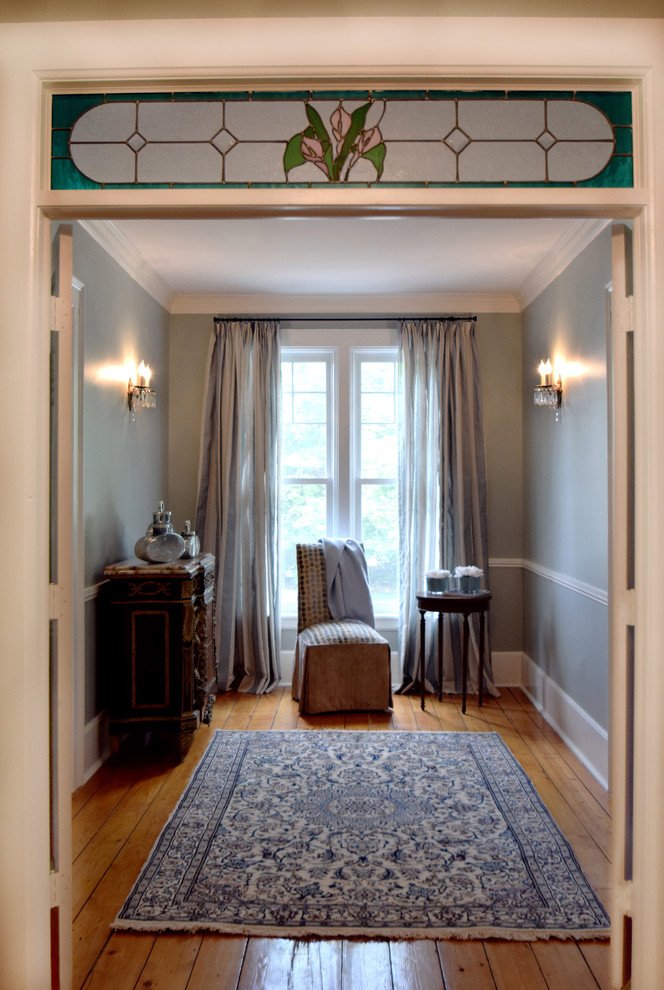 Ejemplo de recibidores y pasillos clásicos pequeños con paredes azules, suelo de madera en tonos medios y suelo marrón