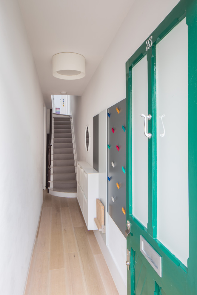 Cette photo montre un petit couloir moderne avec parquet clair.
