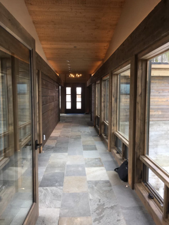 Ejemplo de recibidores y pasillos rústicos de tamaño medio con paredes marrones, suelo de pizarra y suelo gris