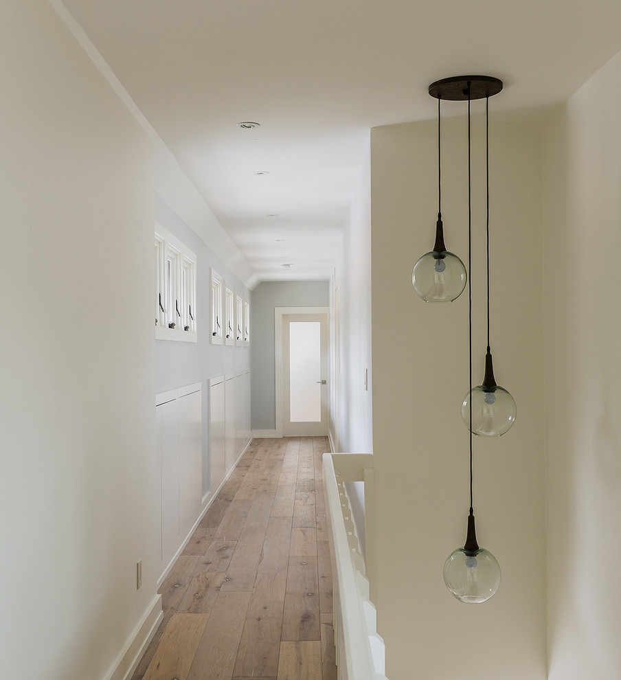 Hallway - large transitional light wood floor and brown floor hallway idea in Boston with gray walls