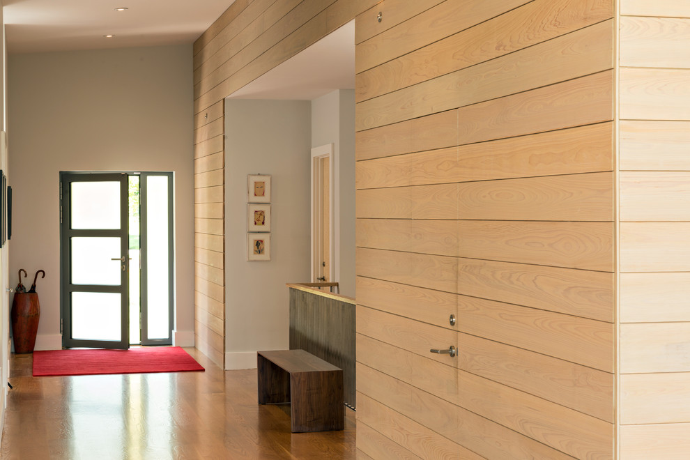 Réalisation d'un couloir minimaliste de taille moyenne avec un mur beige, un sol en bois brun et un sol beige.