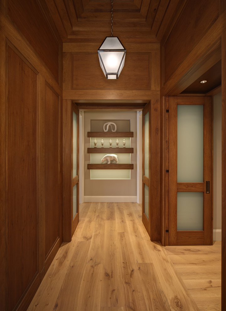 Inspiration pour un grand couloir traditionnel avec un mur marron et un sol en bois brun.