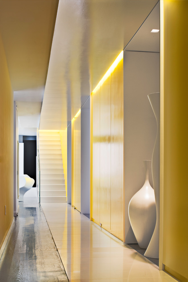Inspiration pour un grand couloir minimaliste avec un mur jaune.