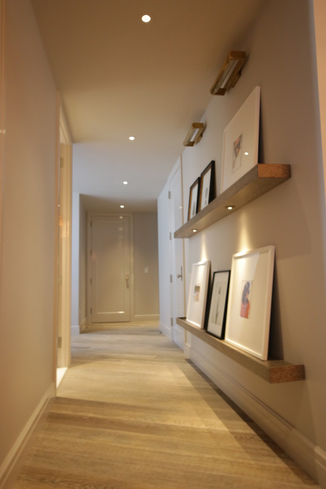 Modelo de recibidores y pasillos actuales de tamaño medio con paredes beige y suelo de madera clara
