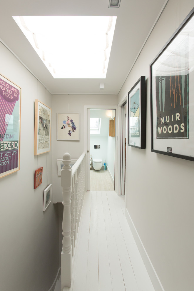 На фото: коридор в стиле неоклассика (современная классика) с серыми стенами, деревянным полом и белым полом