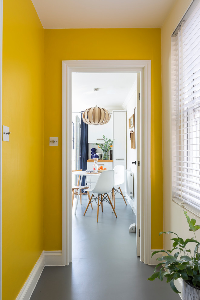 Kleiner Moderner Flur mit gelber Wandfarbe, Vinylboden und grauem Boden in London