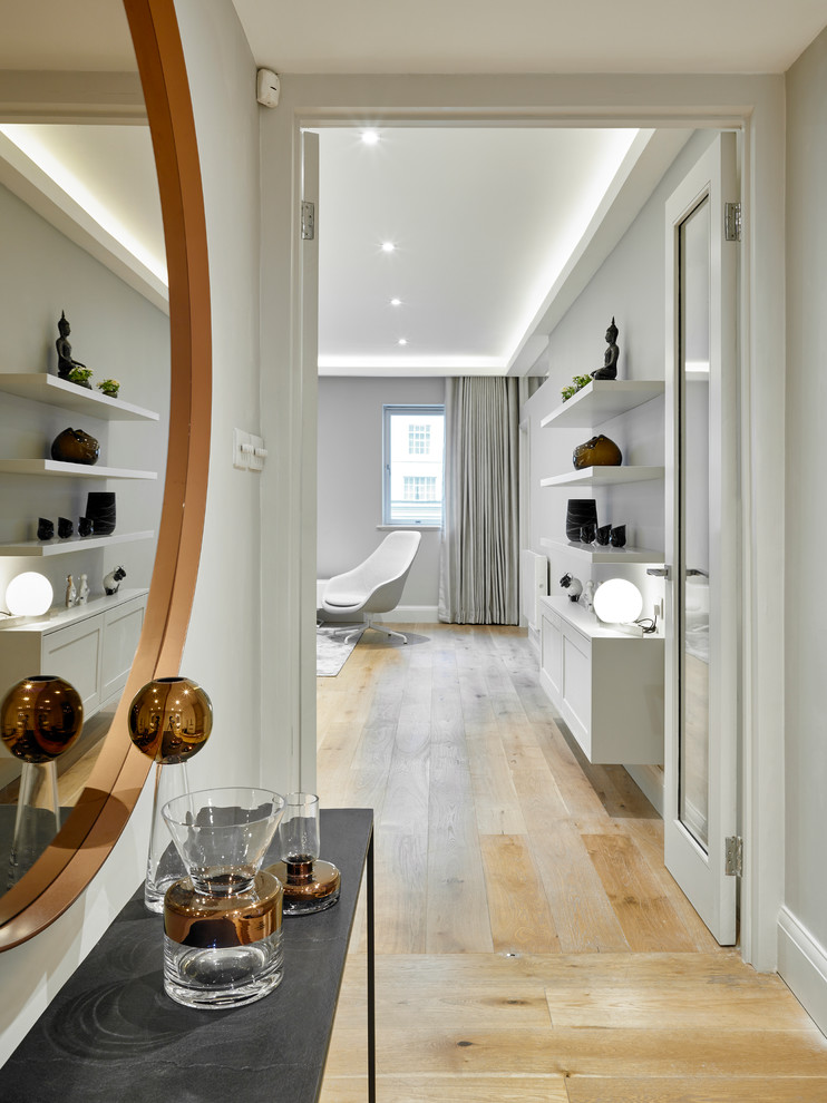 Inspiration for a mid-sized contemporary light wood floor hallway remodel in London with gray walls