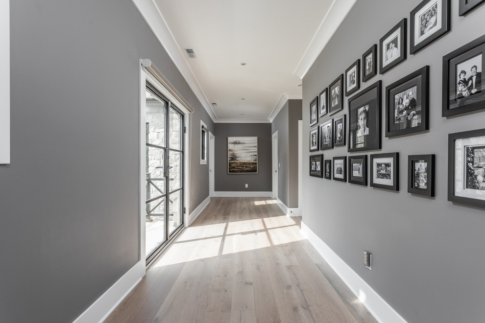 На фото: коридор в стиле модернизм с серыми стенами, паркетным полом среднего тона и коричневым полом с